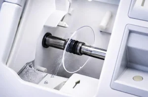 polycarbonate lens being processed by an automatic optical edger